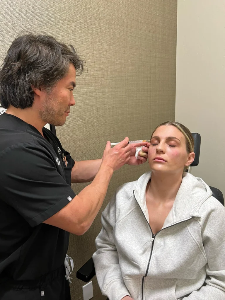 Dr. Chang injecting fillers to a women.